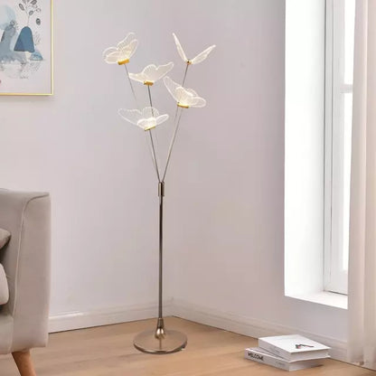 Lámpara de piso con mariposas LED junto a sofá para living luminoso