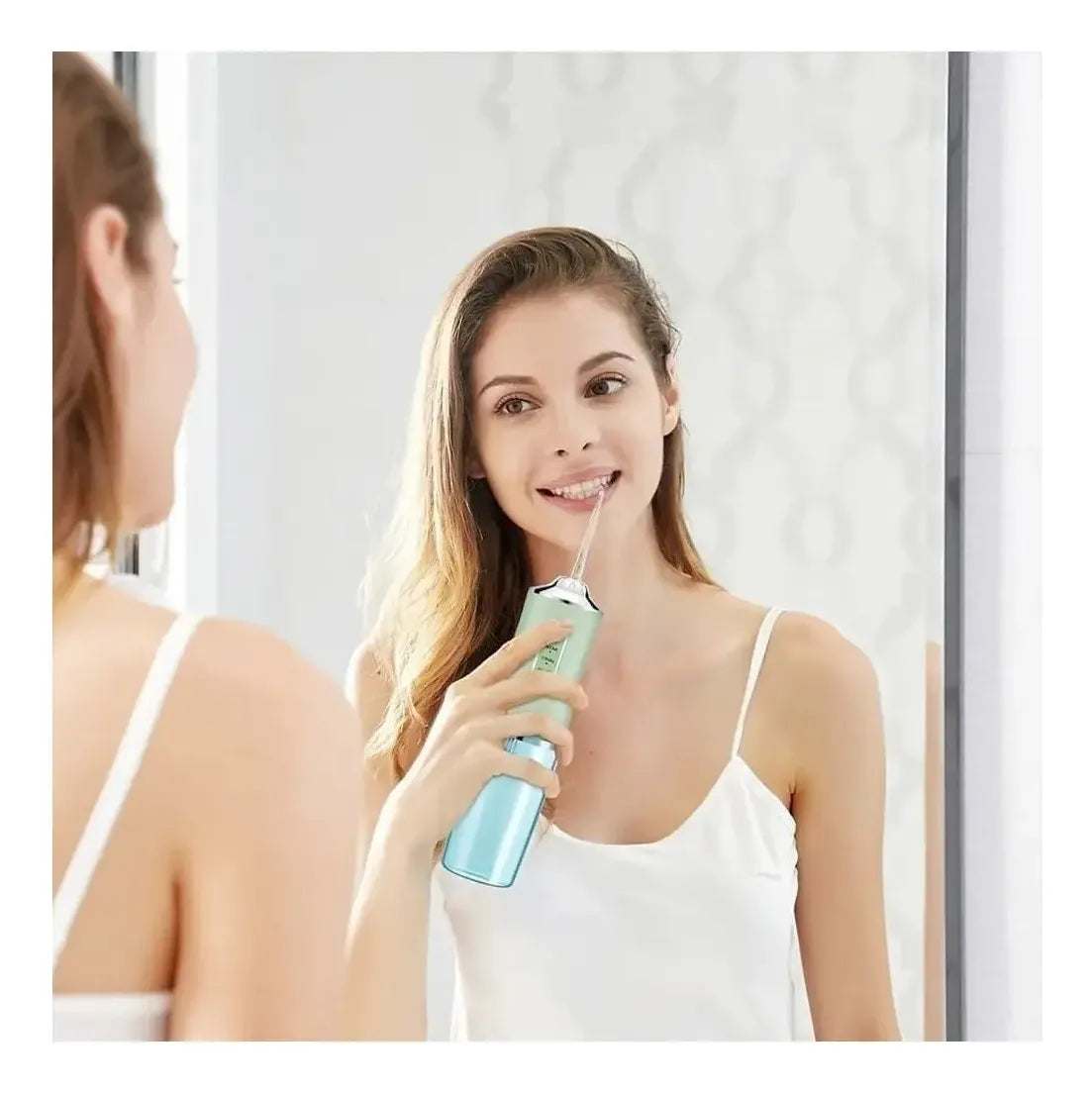 Mujer usando irrigador bucal portátil para higiene dental diaria