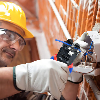 Electricista usando alicate pelacables durante una instalación eléctrica